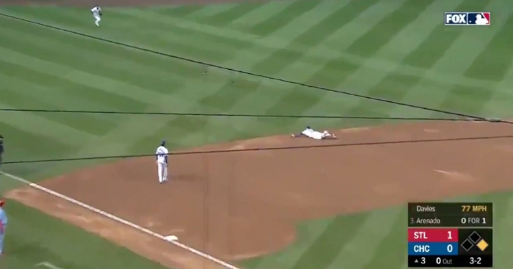 Javier Baez dived onto the infield dirt in order to snag a ground ball hit by Nolan Arenado.