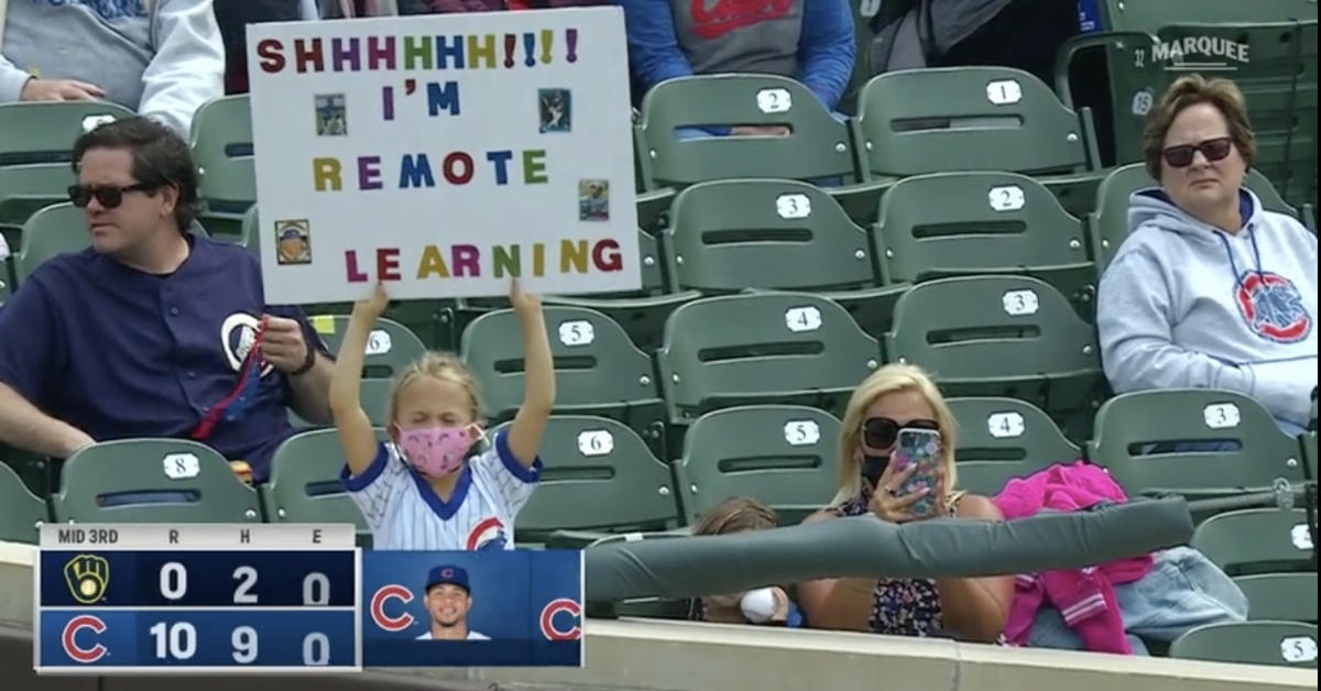 A little girl at Wrigley Field showed off her poster with an interesting interpretation of "remote learning."  (Credit: @SlangsOnSports on Twitter)