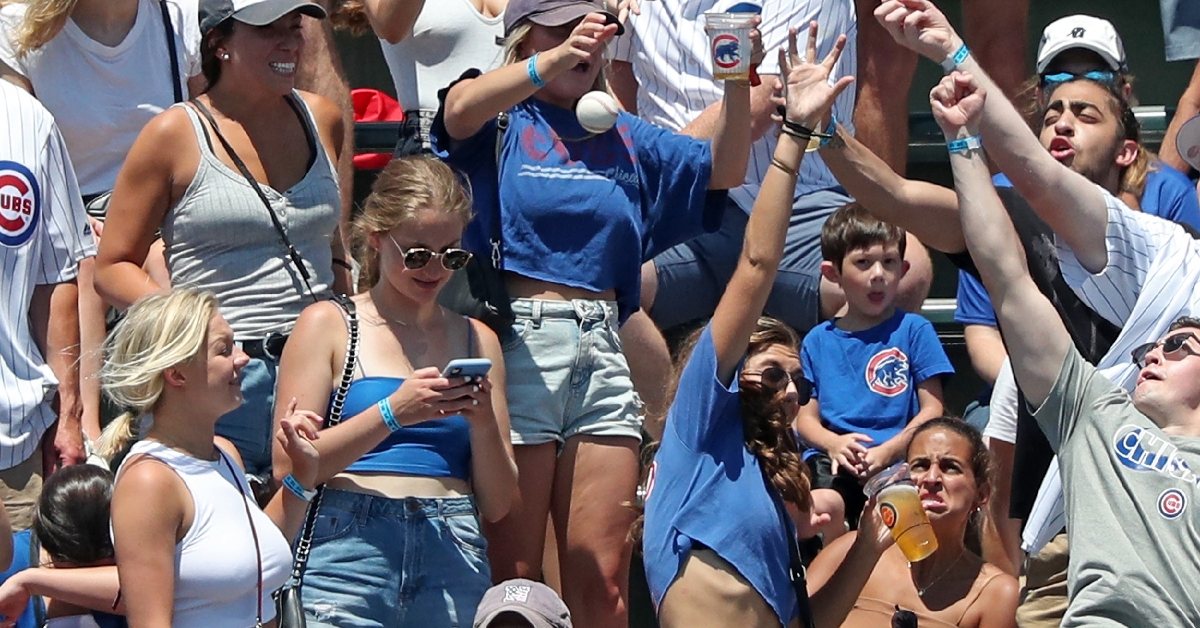 Unaware of the projectile heading toward her, a fan nearly paid the price for staring at her phone in the midst of a Cubs game. (Credit: John J. Kim/Chicago Tribune)